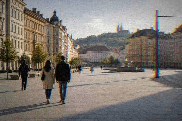 A private guide and a couple seen from behind walking across a very long pale paved square lined with cream and ochre townhouses, Freedom Square