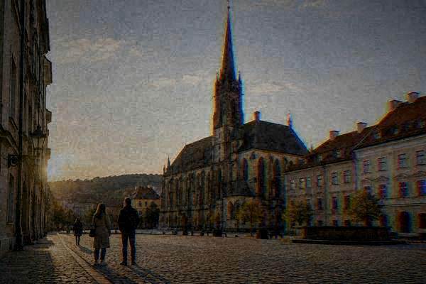 A private guide and a couple pausing on a quiet cobbled square before a tall Gothic church with a single very high slender spire, Church of Saint James