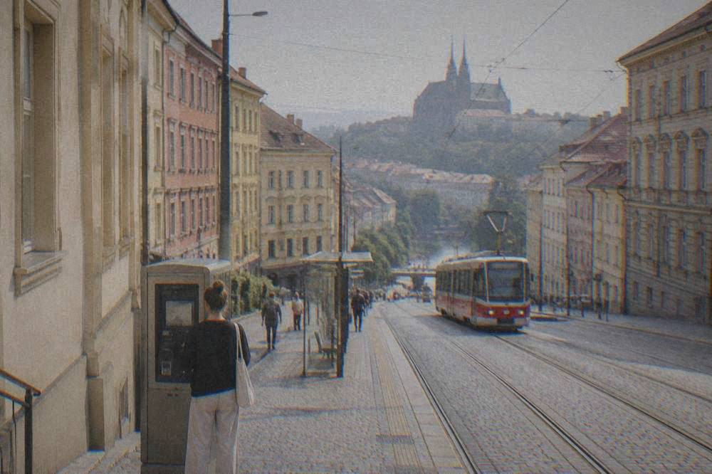 A visitor buying a tram ticket from a machine at a Brno stop