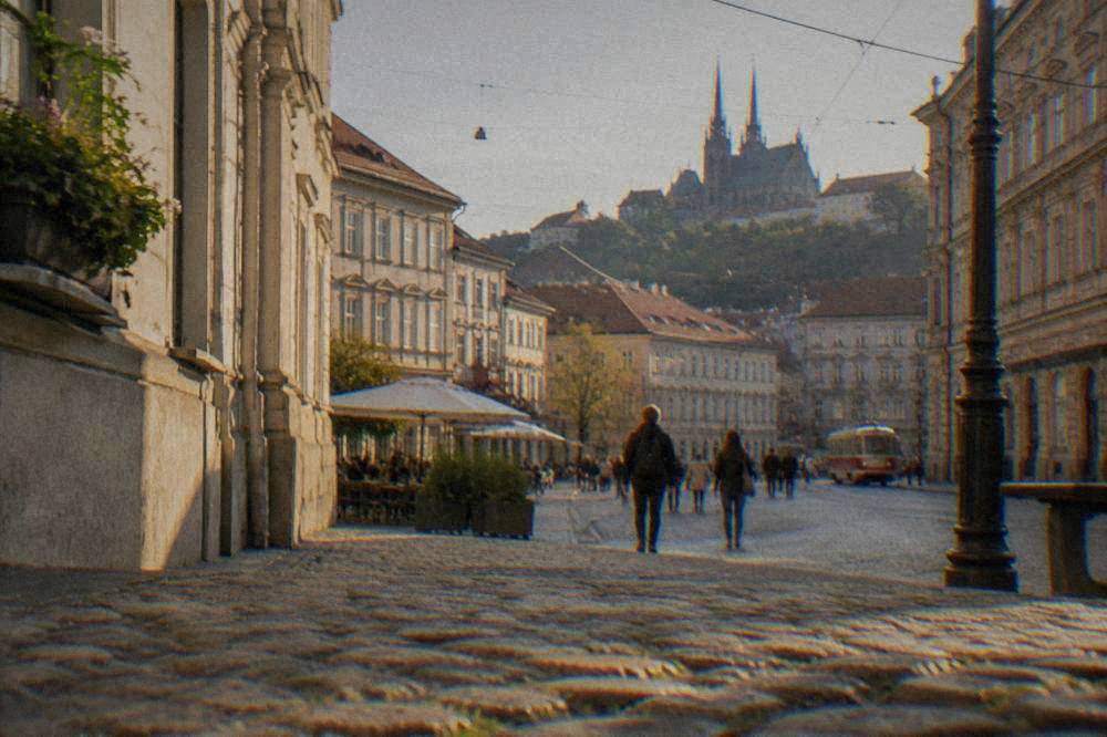 Visitors reading a street sign on a historic square in Brno