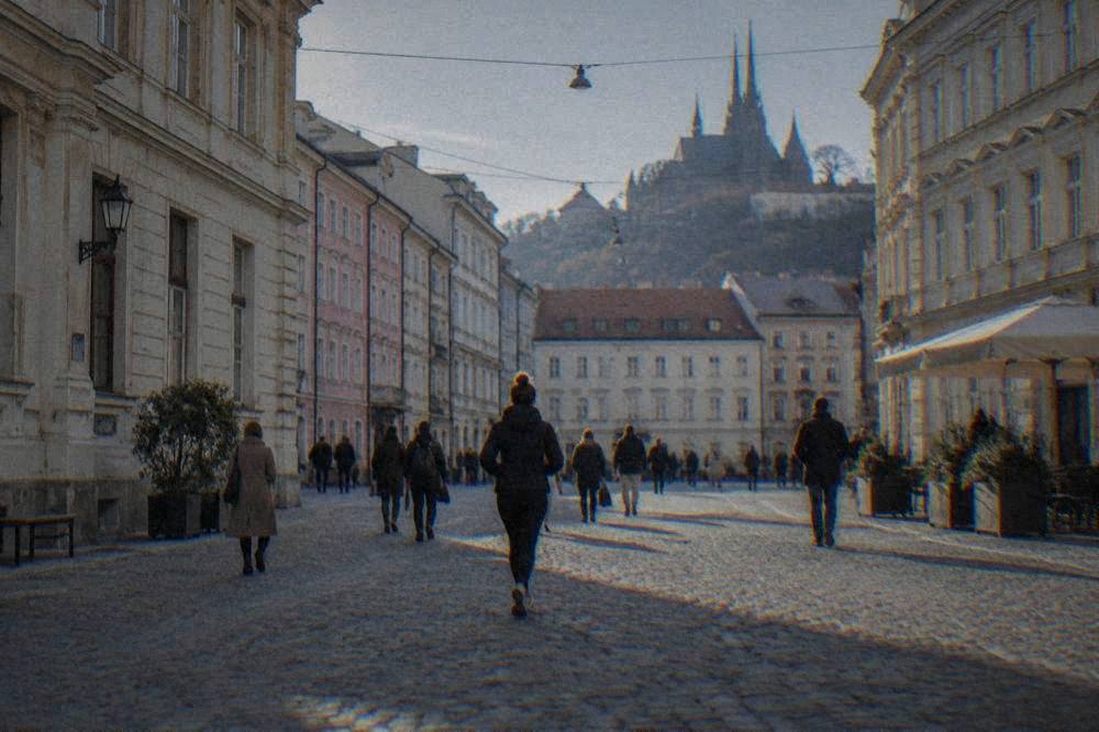 Visitors walking on a cobbled square in central Brno between historic buildings