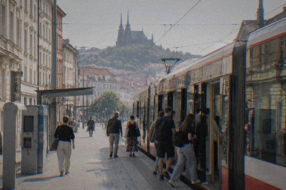 Passengers boarding a modern tram at a stop in Brno with ticket machines visible