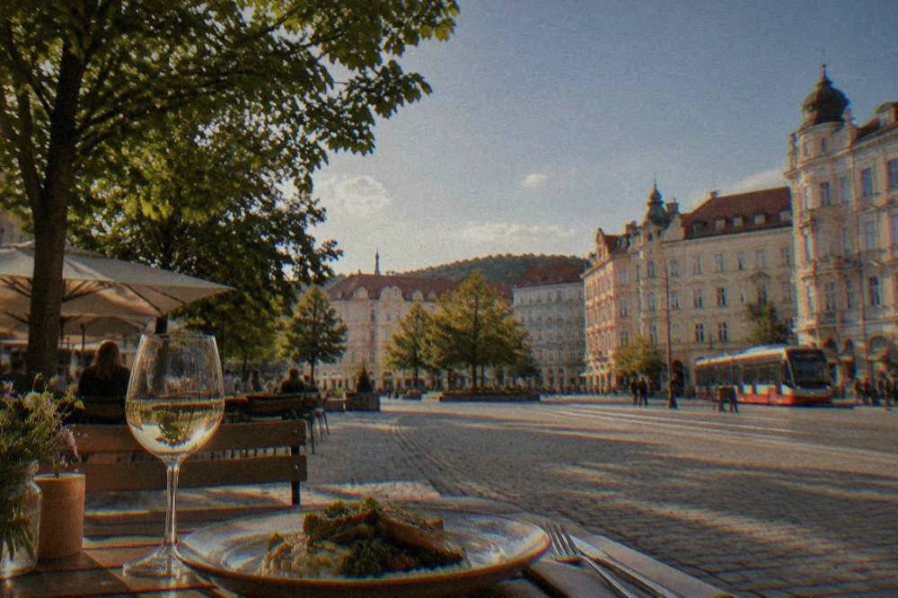 A glass of Moravian wine on a restaurant table beside a plate of food