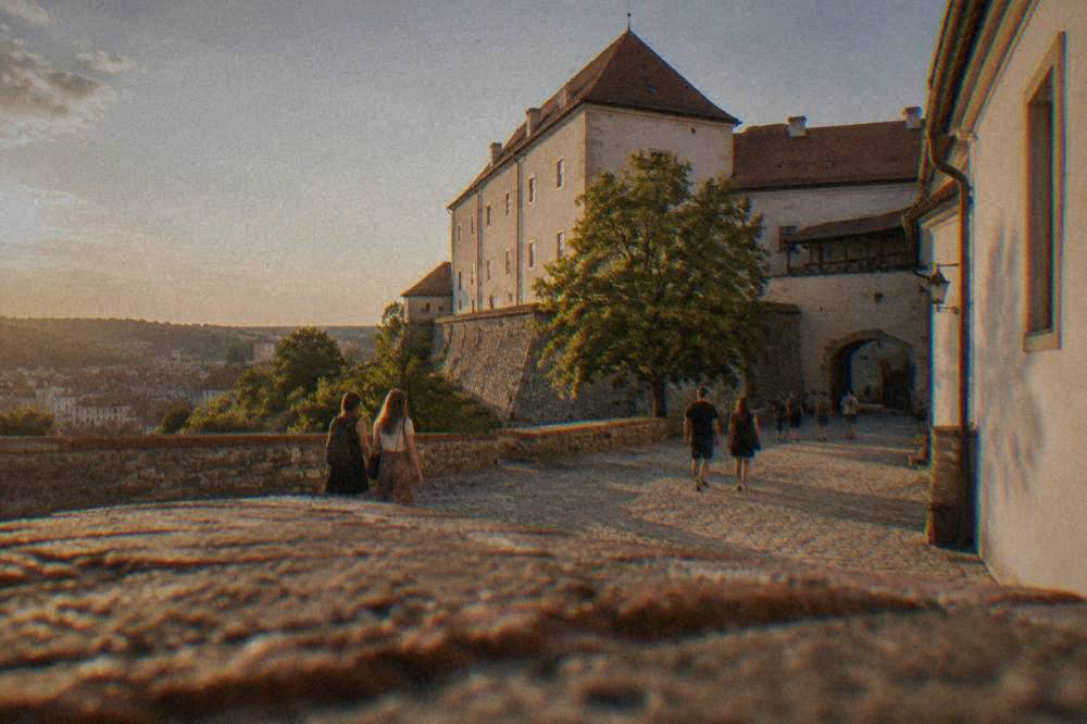 Visitors walking through the courtyard of Špilberk Castle in Brno on a sunny afternoon