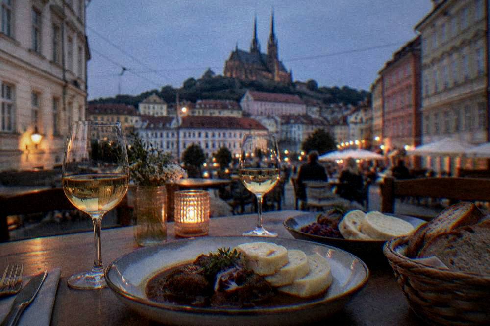 A table with Czech dishes, bread dumplings and glasses of Moravian wine in a Brno restaurant