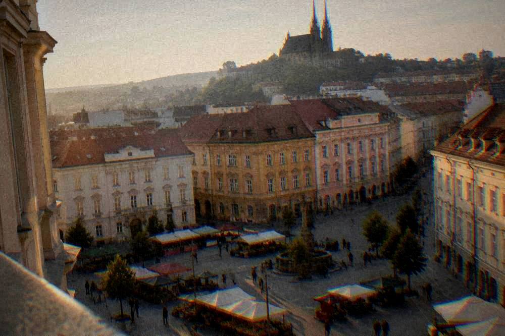 Old town square with market stalls and coloured baroque buildings seen from above