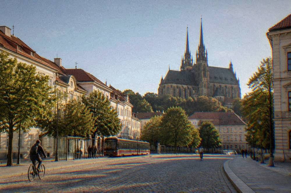 Cobblestone street in Old Brno with the abbey church rising behind trees