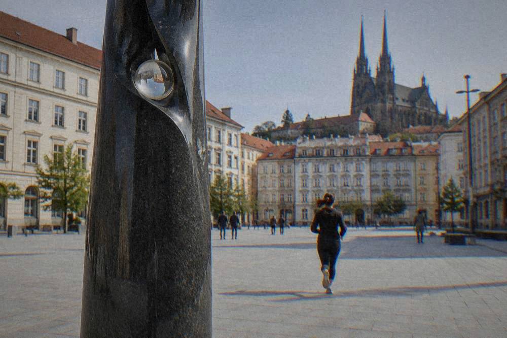 Close view of a dark sculptural pillar with a small glass sphere set into its form