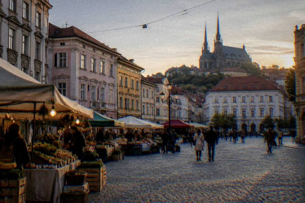 Historic square in Brno with outdoor market stalls at dusk