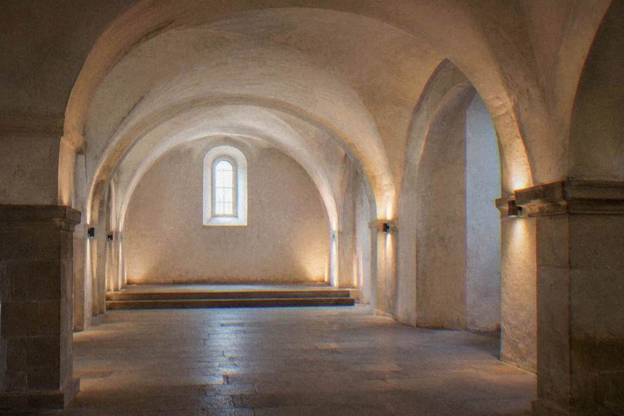 An underground chapel in Brno with stacked bones and dim warm lighting
