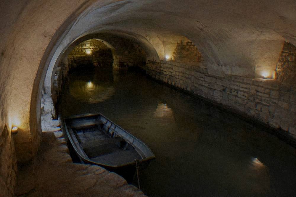 A underground cave passage with an underground river and a small boat