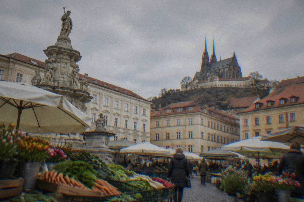 Fresh vegetables and flowers on market stalls in a historic square