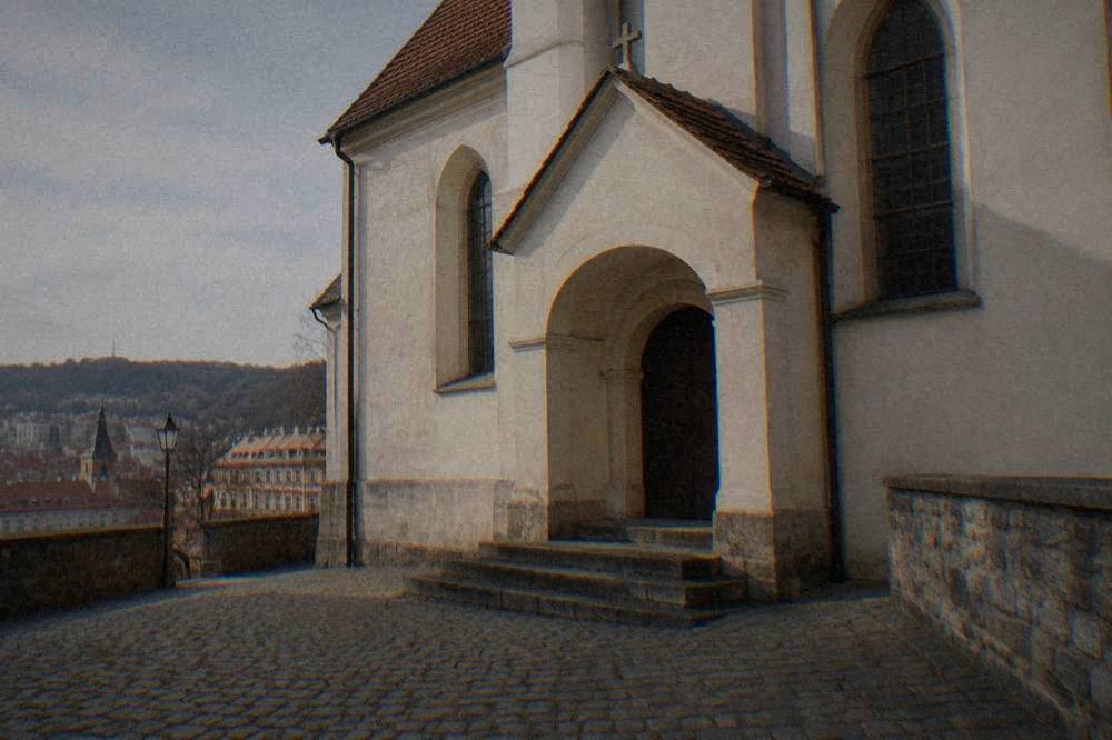 Rows of low arched niches in a dim crypt lit by small lamps