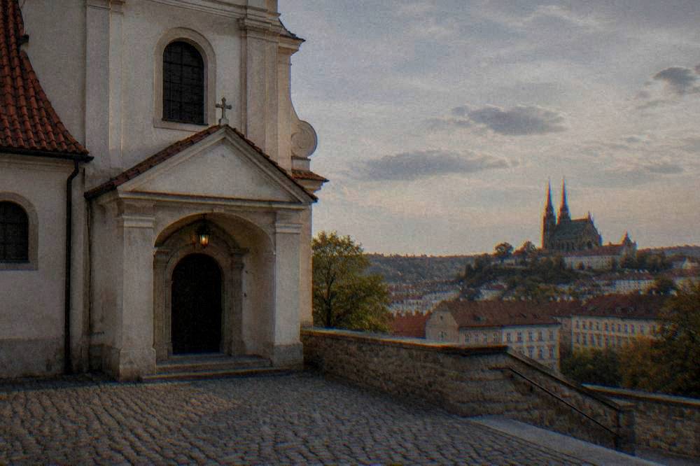 Twin-spired cathedral on a hill overlooking red rooftops of a city