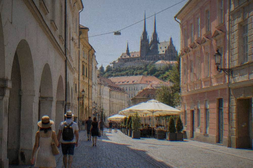 The cathedral spires of Brno under a clear summer sky seen from a city street