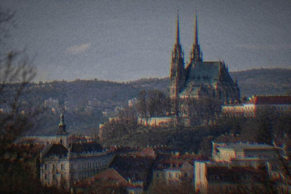 Twin spires of a neo-Gothic cathedral above a hillside and rooftops