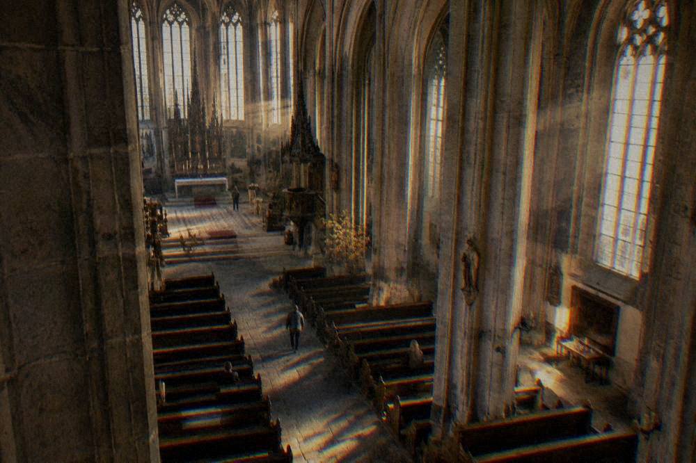 Nave of a Gothic church with tall stone pillars and light falling through high windows