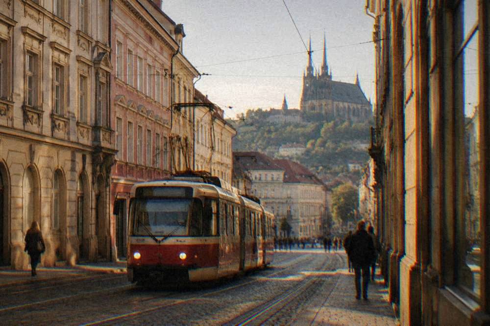 Tram moving along a street lined with historic facades in central Brno