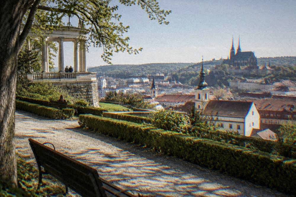 View over red rooftops and church towers of a city from a hillside garden