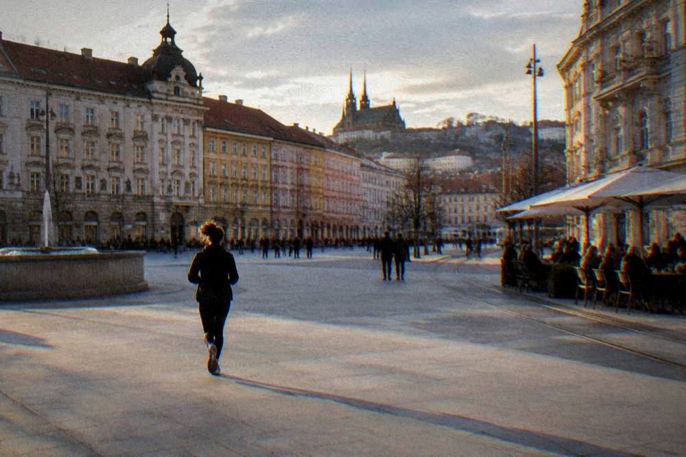 Evening light on a wide European square with people sitting at outdoor tables