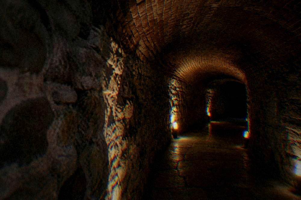Brick-vaulted cellar passage lit from below