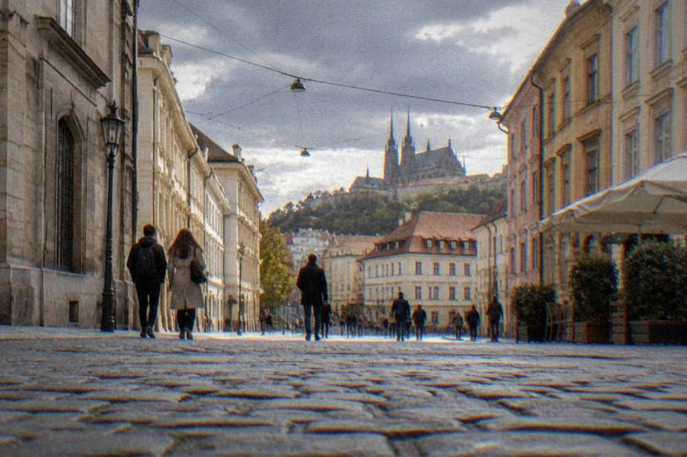 Visitors walking between historic buildings in central Brno under a grey sky