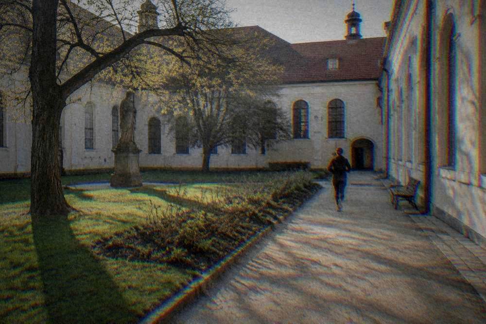Abbey courtyard with a statue and garden beds