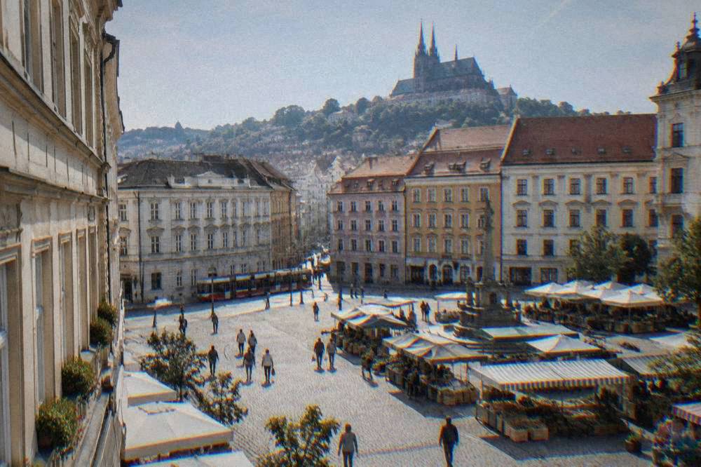 A cobbled square in central Brno with historic townhouses and a market atmosphere