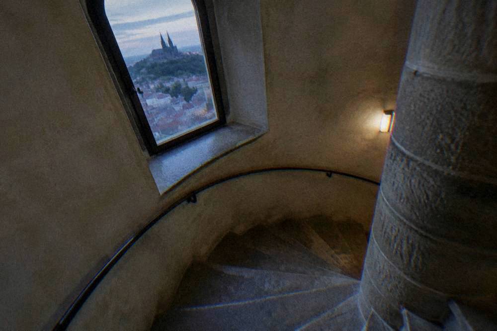 A narrow spiral stone staircase inside a historic tower in Brno