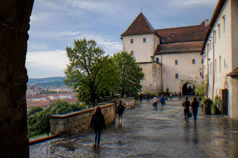 Visitors walking the courtyard of Špilberk Castle in daylight