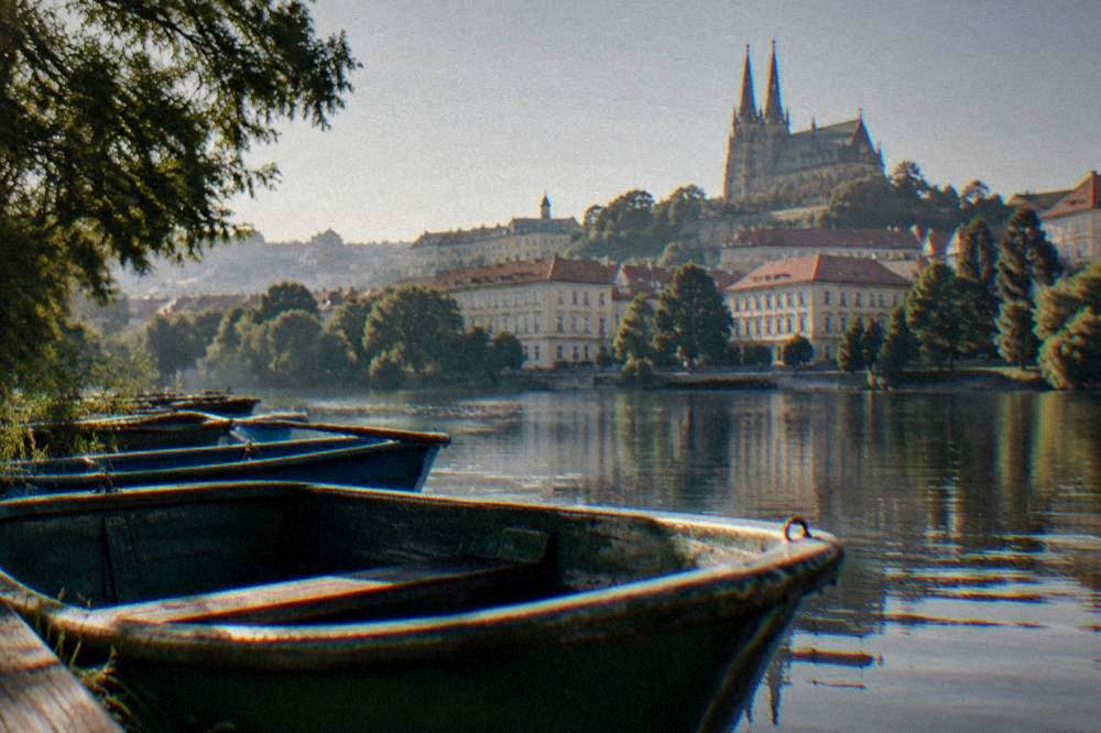Rowboats on a calm lake beside a wooded shoreline near Brno