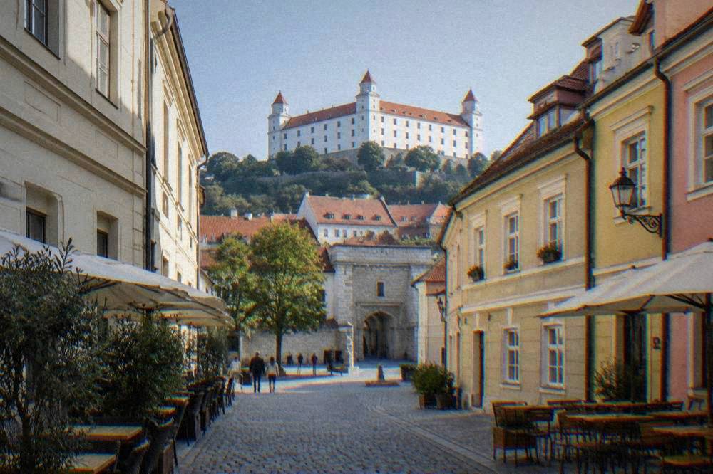 Pedestrian street in a historic old town with colourful facades and outdoor tables
