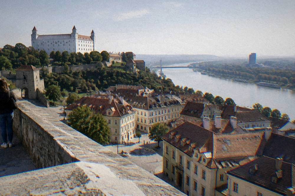 View from a castle terrace over rooftops and a wide river bend