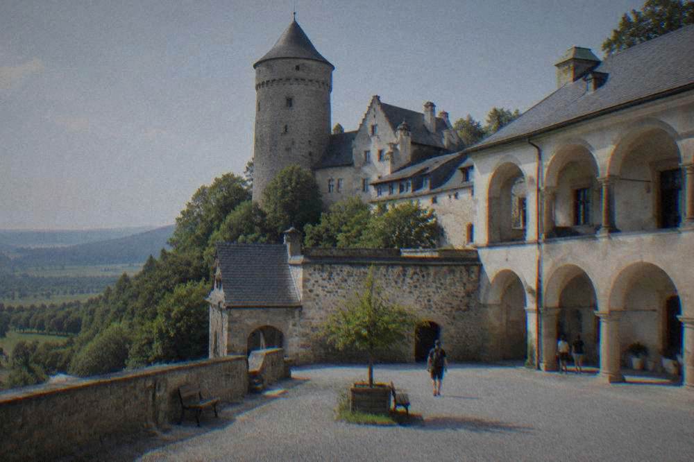 A castle courtyard with arched walkways in afternoon light