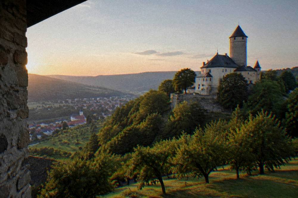Rolling forested hills of South Moravia at sunset with a village below
