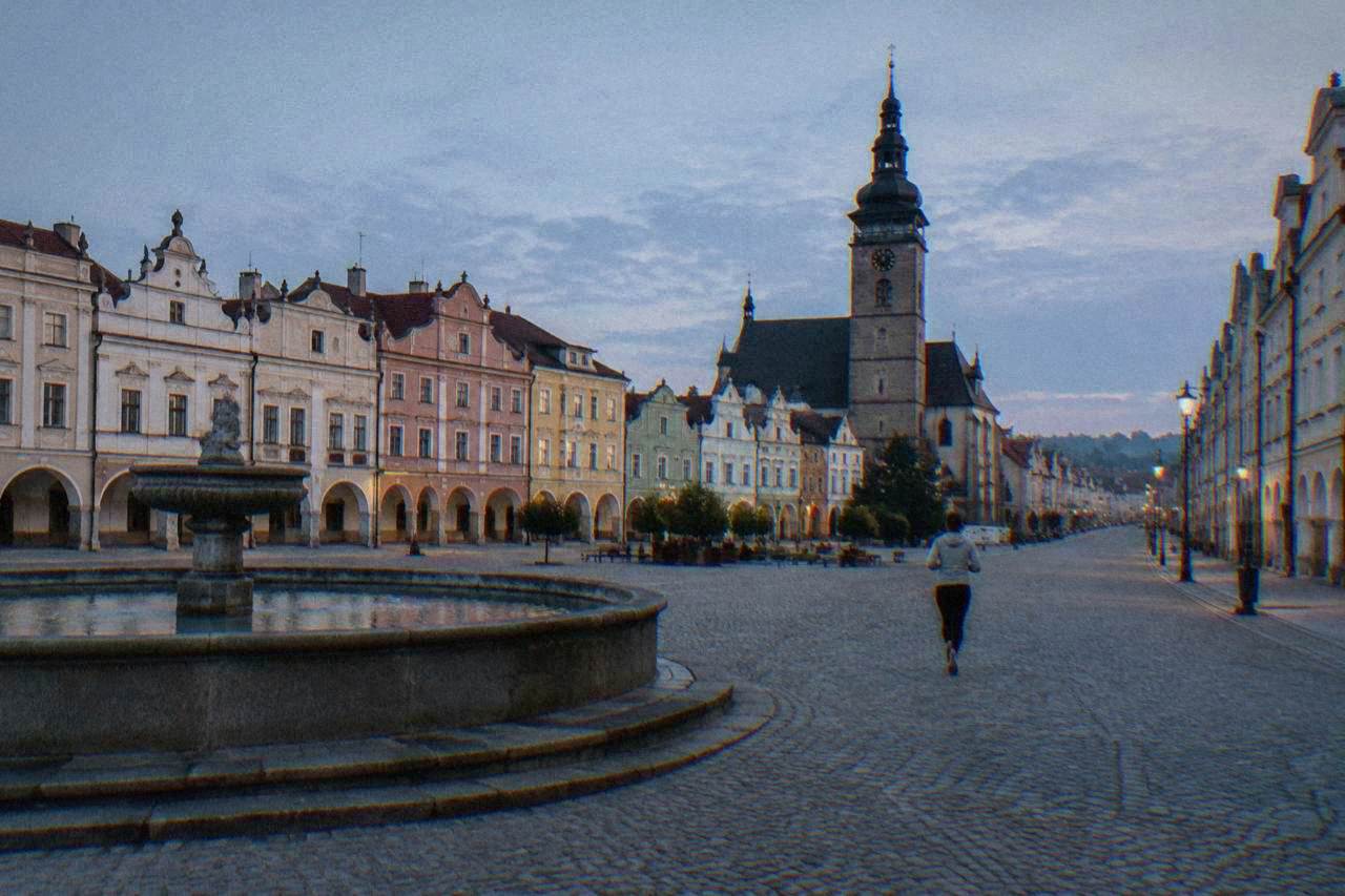 A historic town square lined with colourful merchant houses under a daytime sky