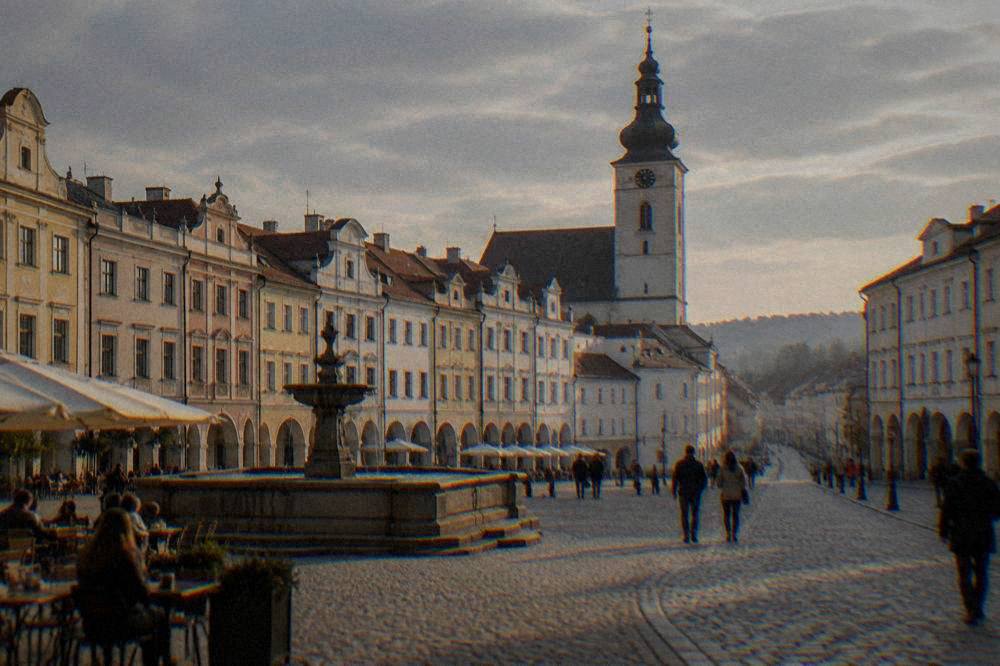A town square with café tables and pedestrians on a mild overcast day