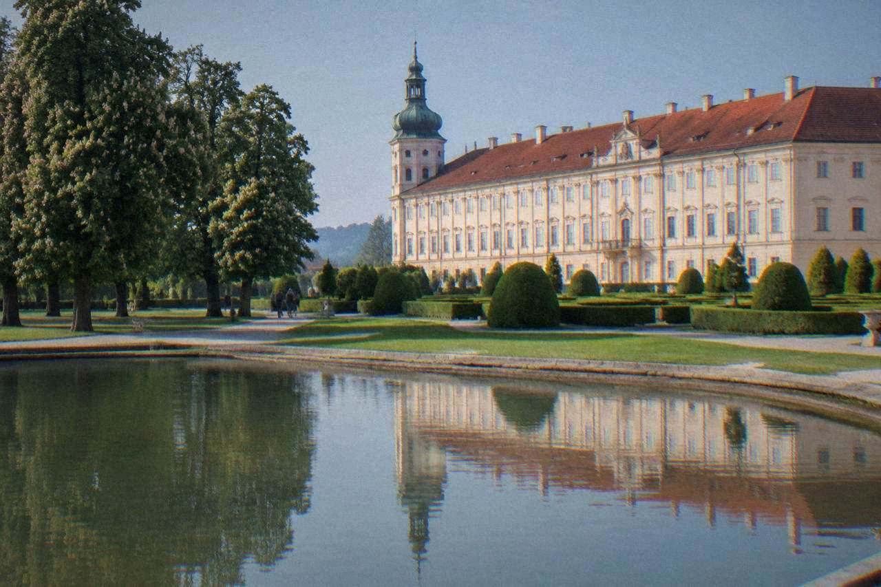 Formal castle gardens in Kroměříž with trimmed hedges and a grand palace building behind them