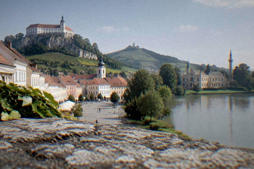 Lednice chateau beside its lake with a tall minaret in the park behind