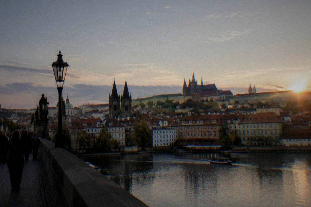 A floodlit castle on a hill above a city skyline at dusk