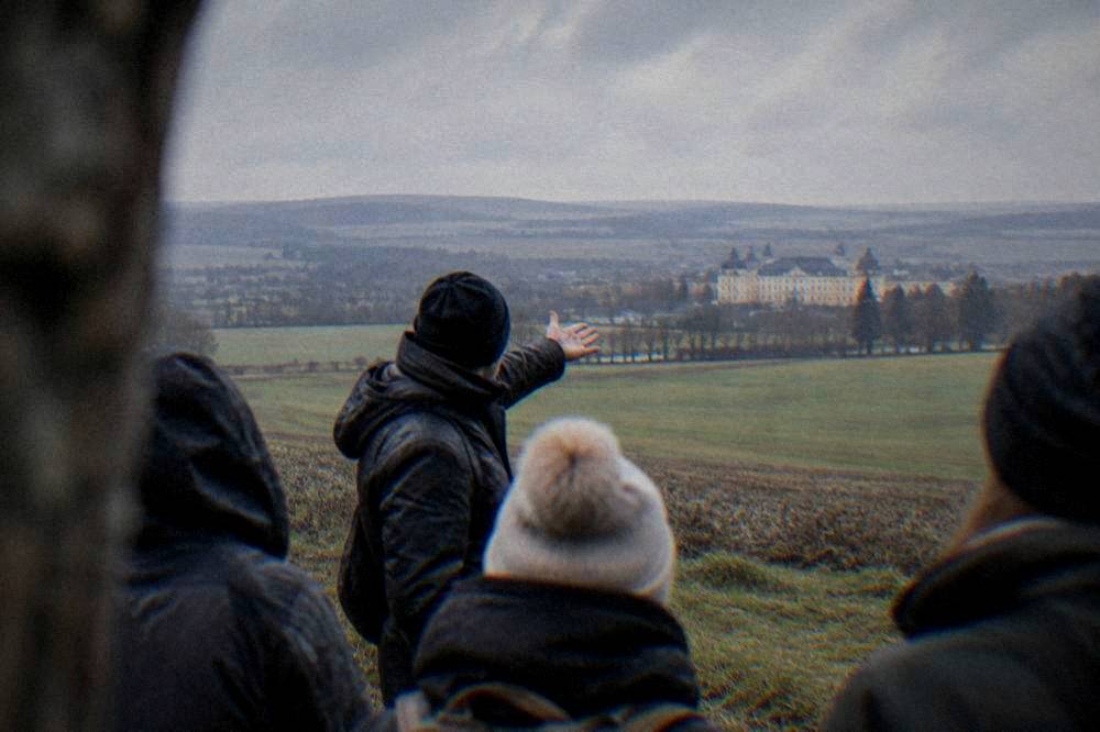 A guide pointing across open fields while explaining the battle to a small group