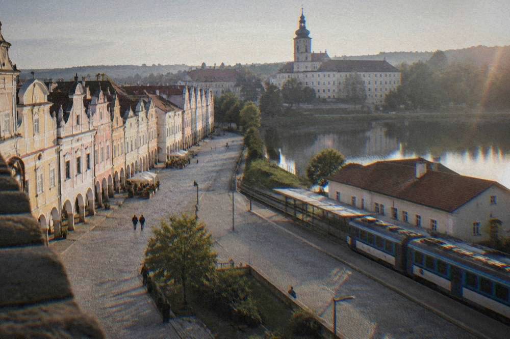 A regional train waiting at a platform beside a low station building