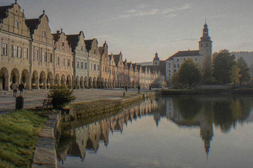 Pastel house facades reflected in the still water of a town pond