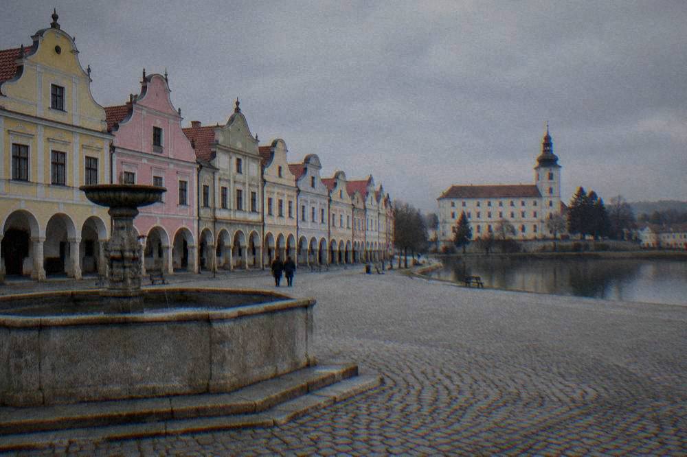 A quiet square with a fountain in front of tall coloured house fronts