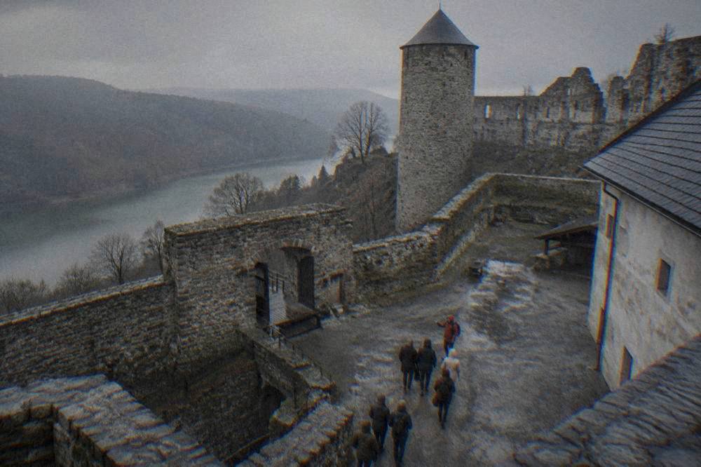 A guide leading a small group of visitors through a castle courtyard