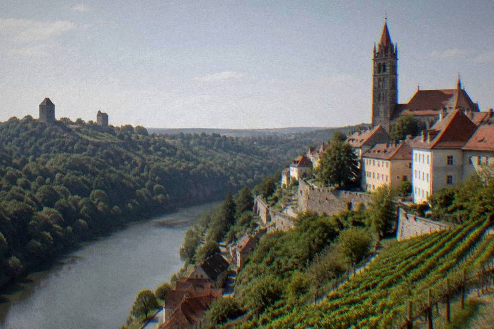 Two medieval castle towers above a forested valley in Moravia
