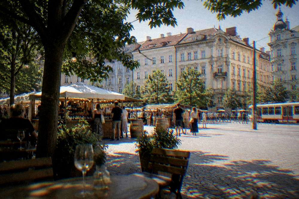 Outdoor festival stalls with wine glasses and string lights on a city square