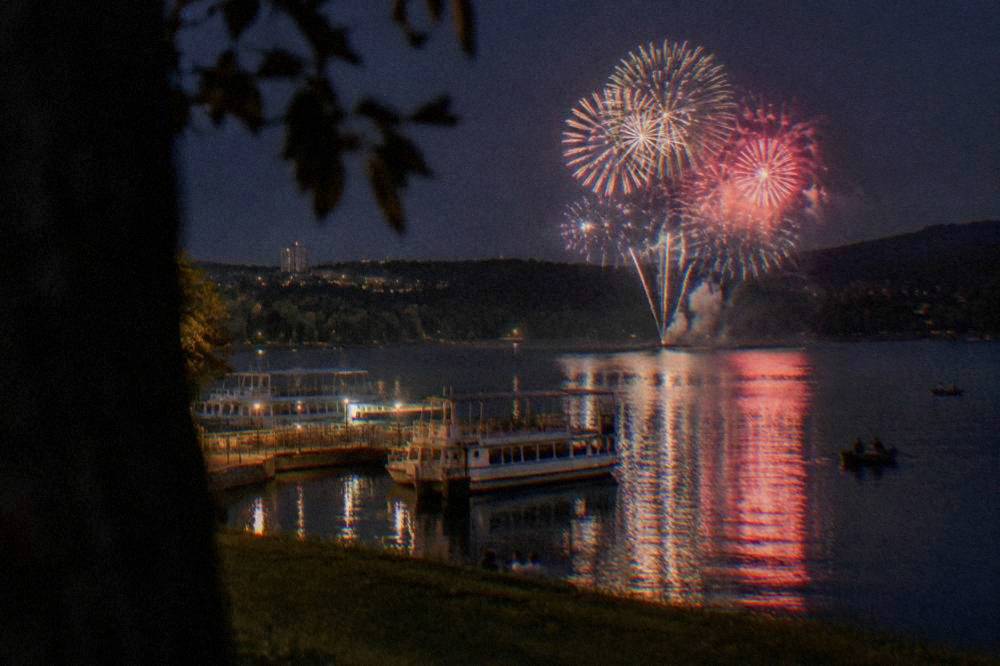 Fireworks bursting over the water of the Brno Reservoir at night