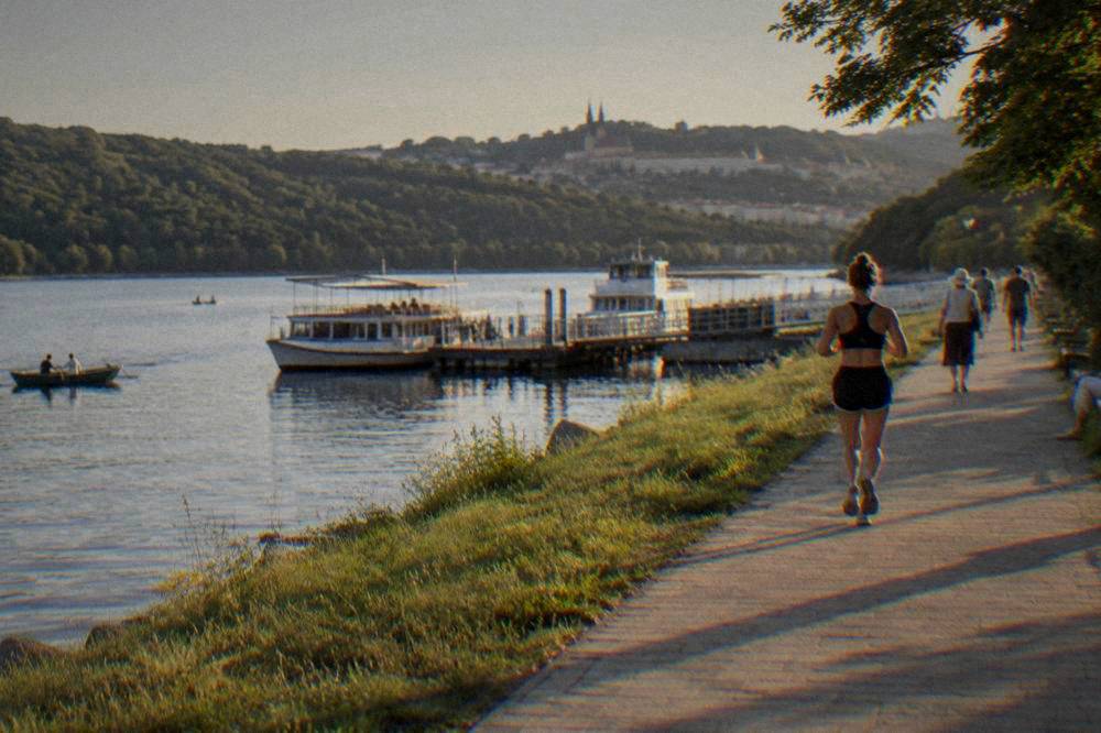 People strolling beside the water of the Brno Reservoir on a sunny summer afternoon
