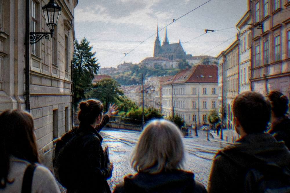 A guide pointing out buildings to a small group on a walking tour in central Brno